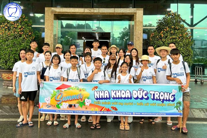 Cả phòng khám mặc áo đồng phục cầm băng rôn Nha khoa Đức Trọng trong chuyến đi hè 2025