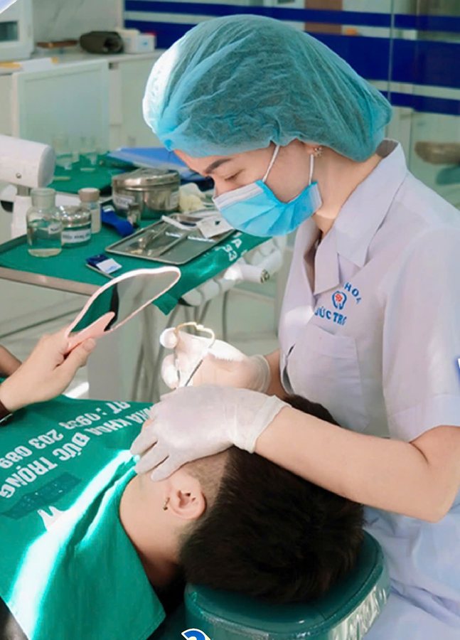 Bác sĩ đang nhổ răng cho khách, khách ngồi trên ghế nha khoa