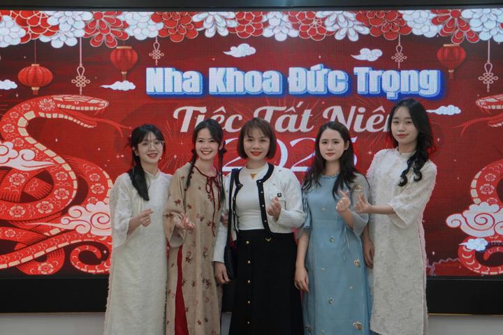 Nhóm nhân viên nữ chụp ảnh trước phông Tiệc Tất Niên