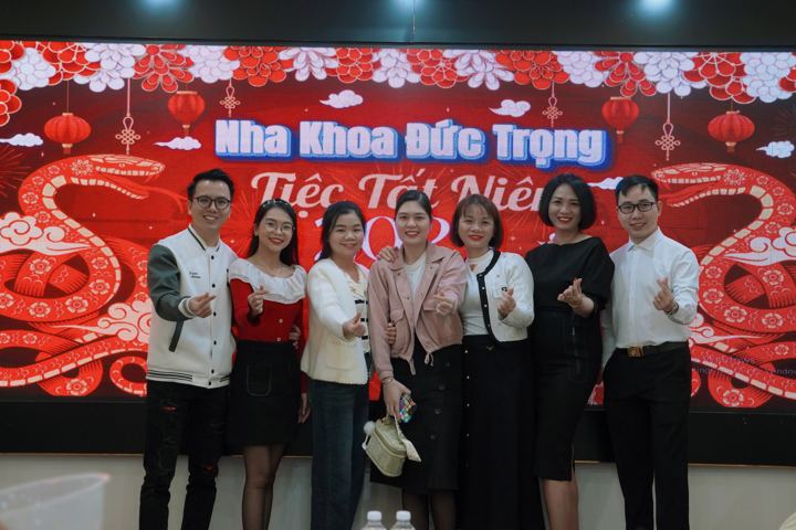 Nhóm nhân viên đứng trước phông Nha khoa Đức Trọng Tiệc Tất Niên 2025