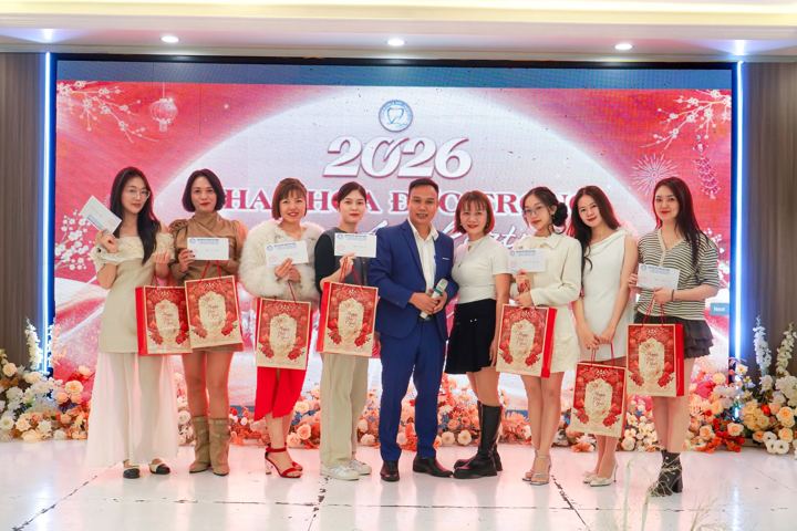 Nhân viên cầm túi quà Tết chụp ảnh trên sân khấu